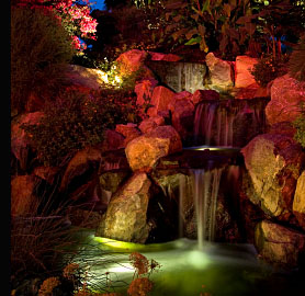 A garden waterfall & pond illuminated by waterproof and submersible lighting