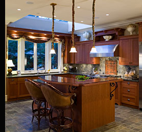 A kitchen featuring low voltage halogen down lights and pendant task lighting over the island breakfast bar